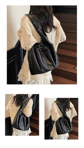Detail of classic black tote bag showing soft pleated leather texture and wide strap
