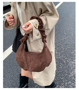 Detailansicht einer braunen Hobo-Tasche aus Wildleder mit gerafftem Griff im Design