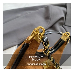 Detail of high-quality gold metal hook and diamond quilted brown suede on shoulder bag