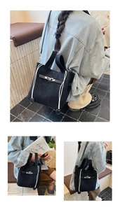 Detail of black matte suede bucket bag with metal clasp and contrasting drawstring accents