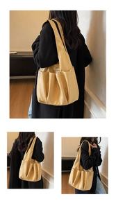 Detail of yellow soft leather tote bag with multi-pocket design and wide shoulder straps