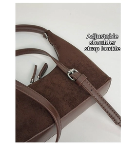 Detailed close-up of the adjustable silver buckle on a dark brown suede leather shoulder bag