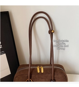 Detail of dual gold zippers and suede texture on a vintage brown shoulder bag