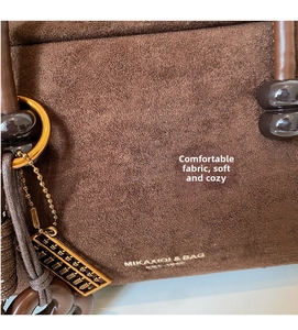 Close-up of soft brown suede material and golden ring hardware on vintage pillow bag
