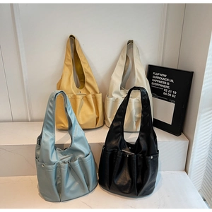 Detail of four colorful tote bags with soft texture, metal snap buttons and outer pockets