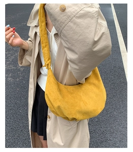 Streetstyle-Ansicht einer gelben Wildleder-Hobo-Tasche mit einem khakifarbenen Trenchcoat