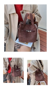 Detail of dark coffee suede bucket bag with silver metal lock and side drawstring