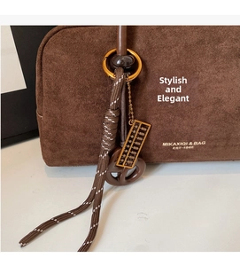 Detailed macro view of vintage brown suede bag with mini abacus and woven rope detail
