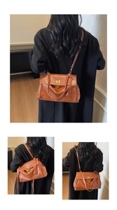 Detail of vintage brown tote bag showing golden twist lock and smooth faux leather texture
