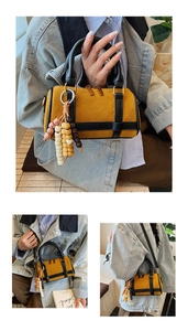 Detail of yellow vintage Boston bag with wooden bead tassel and double metal zippers