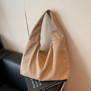 Sac fourre-tout en velours côtelé kaki à rayures et large bandoulière sur canapé