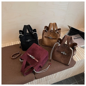 Detail of four matte leather bucket bags with metal turn-lock and side drawstrings