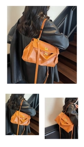 Detail of a brown leather tote bag with dual gold twist-locks and adjustable shoulder strap