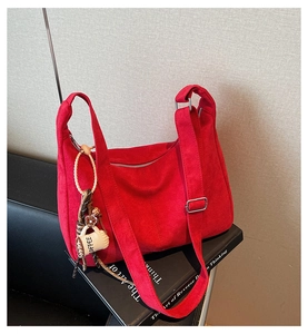 Detail van rode suède shopper met zilveren hardware en een creatieve koffie-bedel
