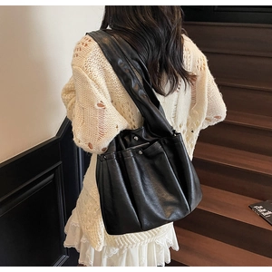Detail of black pleated soft leather shoulder bag with metallic magnetic clasp closure