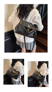 Detail of black pebbled leather tote featuring a polished gold twist-lock closure