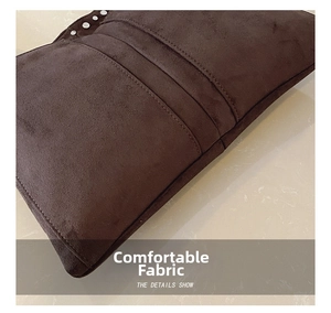 Détail du sac bandoulière en daim marron avec rivets métalliques et coutures décoratives