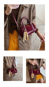 Detail of burgundy suede Boston bag featuring vintage gold zippers and colorful wood beads