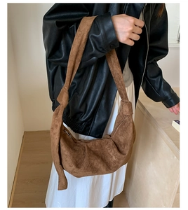 Close-up of brown suede dumpling bag with a unique knot shoulder strap detail
