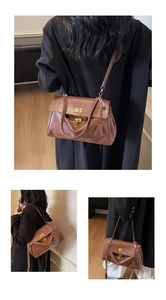 Detail of vintage brown leather bag with golden metal lock and matte texture finish
