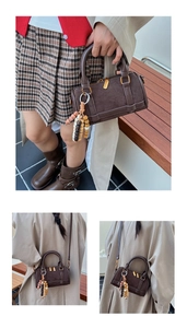 Detail view of mini Boston bag with wood bead tassel and smooth leather texture