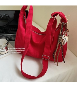Detail van de rode canvas shopper met verstelbare riem en koffiekopje-bedel