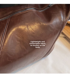 Detail of dark brown leather tote showing fine grain texture and precision stitching