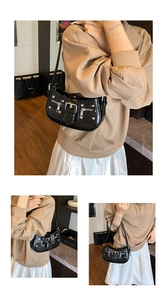 Close-up of black punk style underarm bag with glossy leather and silver hardware details
