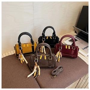 Detailed collection of four leopard print suede Boston bags with wooden bead charms