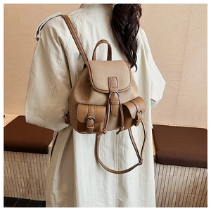 Dettaglio zaino vintage in tela con cinturini in pelle e doppie tasche frontali