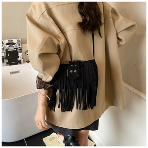 Détail du sac à bandoulière bohème noir à franges avec anneaux métalliques et daim