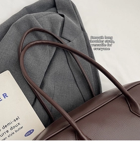 Dettaglio della borsa tote in pelle marrone scuro con spalline lunghe e lisce