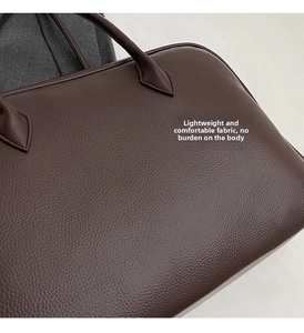 Dettaglio della trama in pelle martellata marrone scuro su una borsa a tracolla minimalista