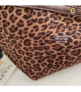 Close-up of leopard print fabric with dark brown leather trim and metal grommet detail