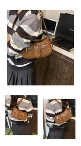 Detail of brown vintage leather bag with silver rivets and metal buckle hardware
