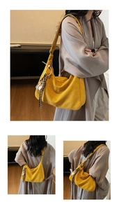Detail of large mustard yellow suede shoulder bag with COFFEE charm and wide strap