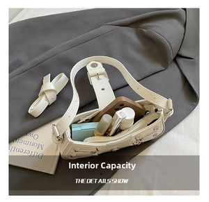 Detail view of white rivet shoulder bag showing internal capacity for phone and makeup
