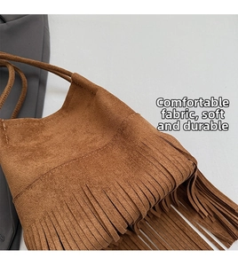 Detail of brown faux suede fabric and long fringe tassels on a bucket shoulder bag