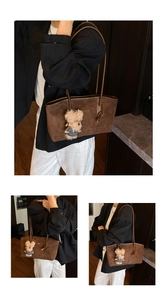 Detail of dark brown tote bag with suede texture and a cute teddy bear charm