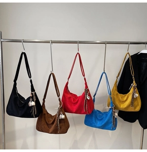 Rij kleurrijke hobo-tassen van suède met decoratieve koffie-hangers en franjes