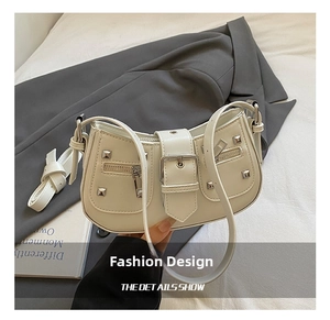 Detail of cream PU leather shoulder bag with vintage silver rivets and buckle straps
