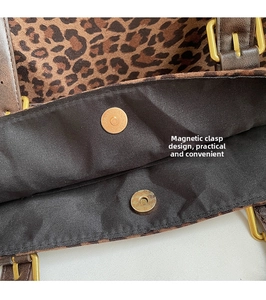 Close-up of leopard print tote featuring magnetic snap closure and leather strap details