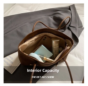 Detail view showing interior capacity of a brown faux suede tote bag with daily essentials