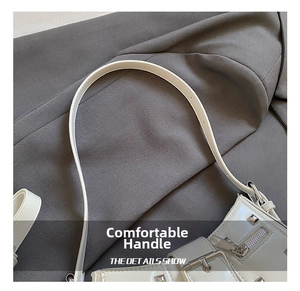 Close-up of white leather shoulder bag with silver punk rivets and adjustable strap details