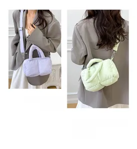 Detail of quilted puffer tote bag in purple and mint colors with adjustable straps