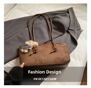 Detail of vintage matte brown tote bag with suede texture and plush bear charm