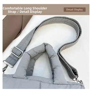 Detail view of the gray quilted tote bag showing adjustable straps and silver hardware