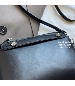 Detailansicht der schwarzen Handtasche aus Kunstleder mit silbernen Nieten und Nähten