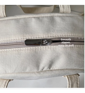 Detail shot of smooth metal zipper and water-resistant micro-texture fabric on bag