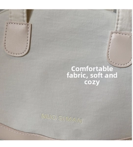 Detail of grid texture fabric and leather patchwork on beige mini crossbody shell bag
